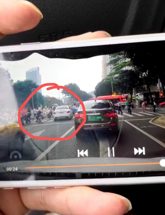 白色车两闯红灯撞上行人。视频截图