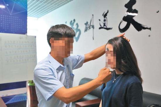  ▲6月19日，北京双优贝贝公司，记者体验额头吸附硬币。专家表示，此种现象仅因为摩擦力产生，没有所谓磁场一说。新京报记者 王飞 摄