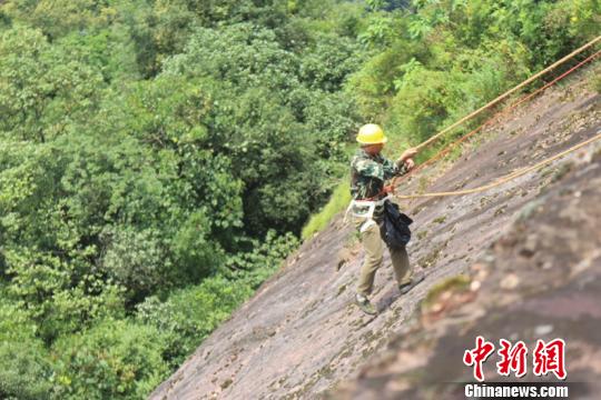 丹霞赤壁上的环卫者用生命守护珍贵自然遗产