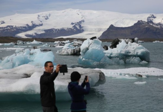 游客在冰岛东南部瓦特纳冰原国家公园的杰古沙龙湖游览。（新华社/欧新）
