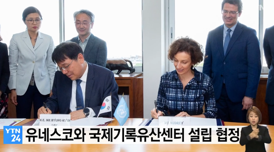 12日，韩方代表与联合国教科文组织总干事签署协议。（YTN电视台）