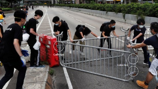 图8，示威者用塑料扎帶将路障、护栏以及道路指示标识固定。