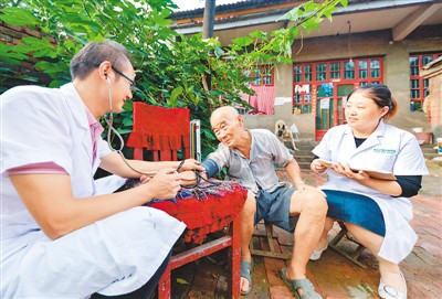 在河北省邯郸市大名县西未庄乡许堤村，翟大龙（左）、王翠红夫妻在村民家中为其测量血压并记录健康状况。 新华社记者 王 晓摄