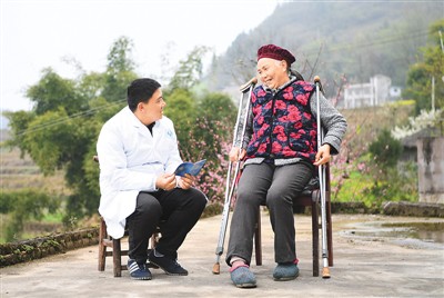 乡村医生向重庆市云阳县龙角镇泉水村村民沈传杰（右）宣传介绍医疗保障政策。新华社记者 王全超摄
