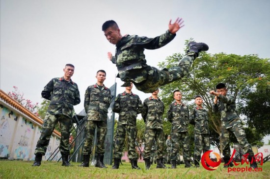 两名武警官兵在进行摔擒动作示范。