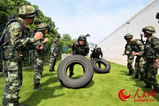 两名武警官兵在进行翻动轮胎比拼。