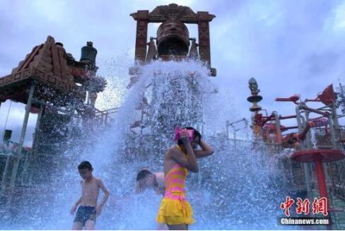资料图：高温天气里，民众来到水世界戏水玩耍、消暑纳凉。中新社记者 王东明 摄