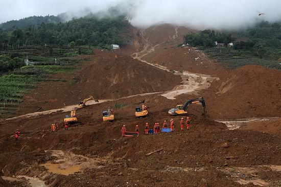 救援人员在山体滑坡现场开展救援。