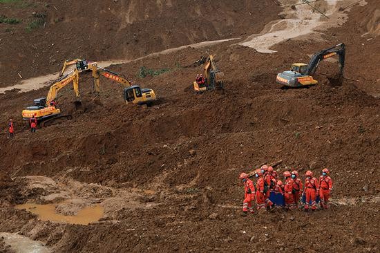 救援人员在山体滑坡现场开展救援。