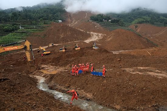 救援人员在山体滑坡现场开展救援。