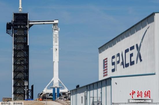 资料图：美国佛罗里达州卡纳维拉尔角空军基地，搭载无人驾驶“载人龙飞船”的SpaceX猎鹰9号火箭伫立在发射台上。