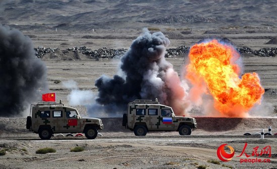 中俄双方参赛队员驾驶车辆通过防护区。