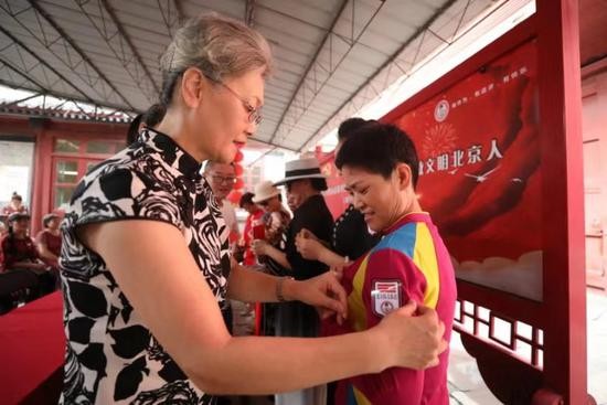 嘉宾为参与活动的大妈授发标志牌。新京报记者 王飞 摄