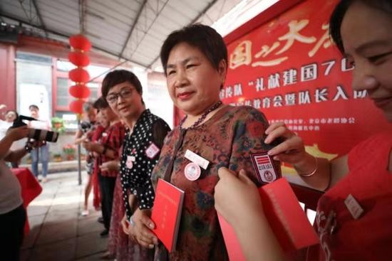 嘉宾为参与活动的大妈授发标志牌。新京报记者 王飞 摄