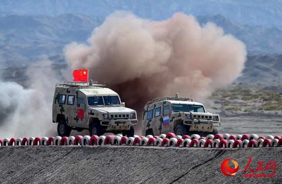 中俄双方参赛队员驾驶车辆通过土岭。