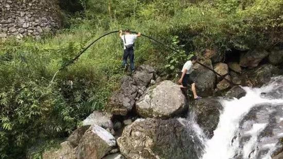 △村民在悬崖下寻找周康云