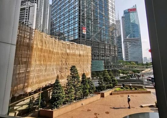 法籍男子在商厦外挂印有中国国旗及香港特别行政区区旗图案的旗帜(图片来源:东网)