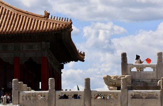 小女孩拿着红旗在游览最美紫禁城。