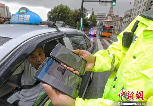 民警对电子驾驶证进行信息核验。　殷立勤 摄