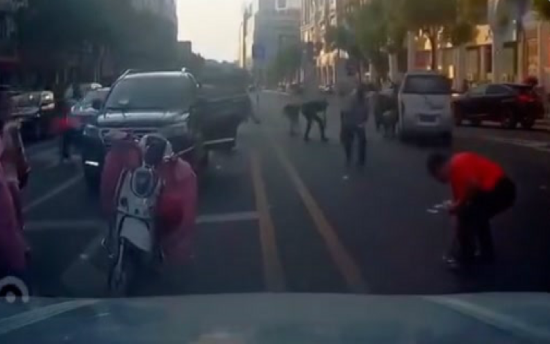 ▲福建一男子沿路撒十余万元现金。  图片来自视频截图。