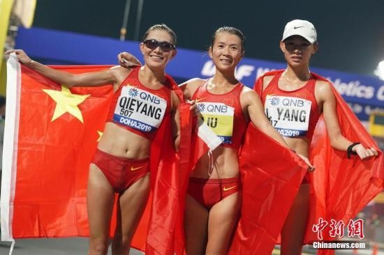 图为刘虹(中)、切阳什姐(左)和杨柳静(右)手持国旗庆祝。中新社记者 泱波 摄