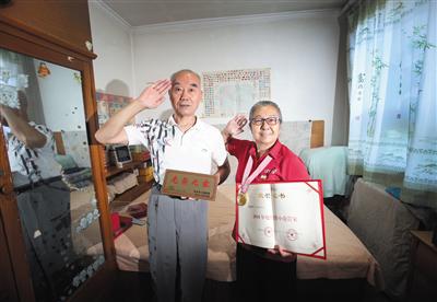 7月28日，孙宝珍和丈夫吴玉展示&ldquo;光荣之家&rdquo;牌子和金牌小巷管家荣誉证书。