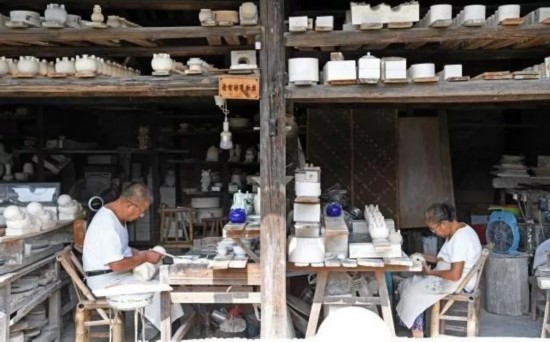 ▲景德镇老窑厂内的工匠们（新华社）