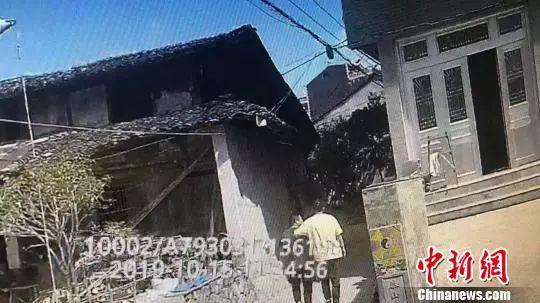 　警员搭着嫌疑人的肩膀，若无其事地走出村子。陈笑供图