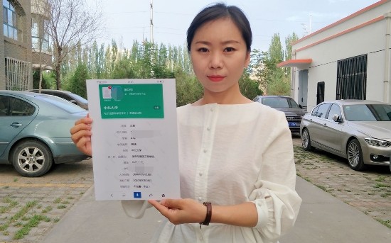 麻巧珍手持冒用者的学籍信息截图。 受访者供图