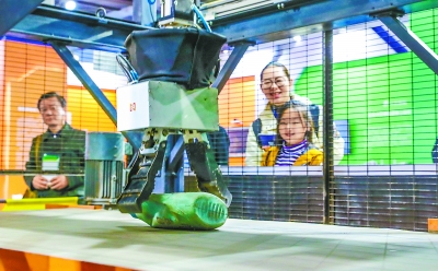 在科博会北京展区，参观者观看智能垃圾分类机器人。本报记者 武亦彬摄