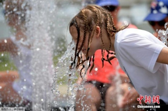 资料图:澳大利亚墨尔本,强热浪席卷其南部各州,女孩在喷泉中降温。