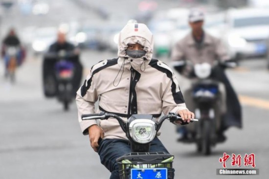  资料图：民众穿厚衣出行。武俊杰 摄