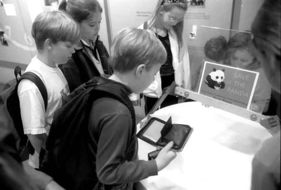 2000年5月21日，一些美国孩子在美国国家动物园大熊猫馆内为拯救大熊猫基金会捐献硬币。新华社记者王岩摄