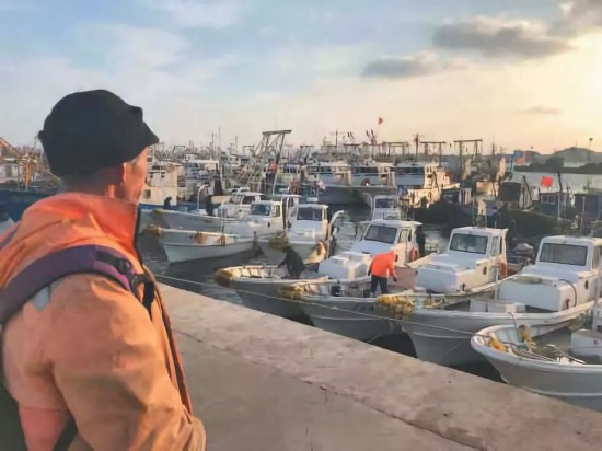 ▲11月15日清晨，渔民李国来到岸边查看他的小船，天气好的时候就出去打打鱼。