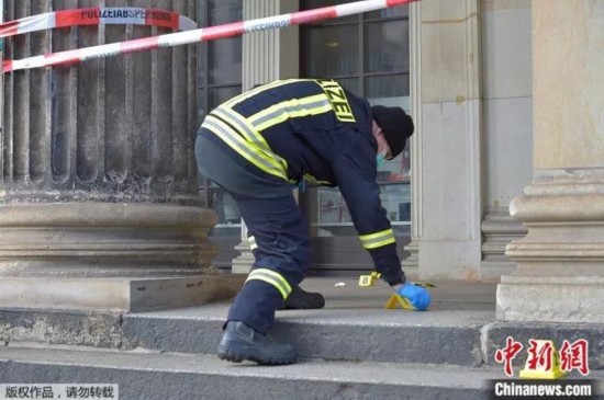 一名警察在绿穹珍宝馆外检查嫌犯留下的证据。
