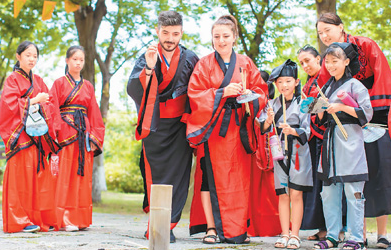 浙江省长兴县陈武帝故宫内,外国游客和学生们一起体验投壶游戏。吴拯 彭光建 摄(人民图片)