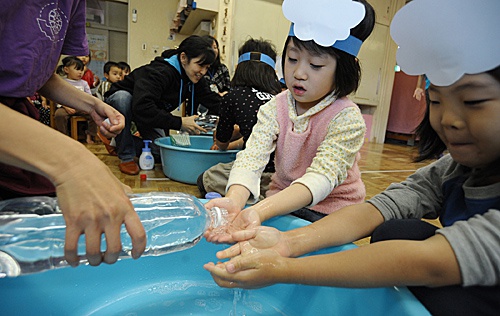  在日本横滨的中屋敷幼儿园，孩子们在学习完洗手操后洗手。（新华社）