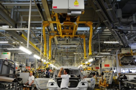 资料图片:英国柴郡克鲁的宾利工厂,工人在配件装配车间作业。(新华社)