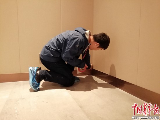 验房师马师傅正在检查墙体是否存在空鼓等问题。中青报&middot;中青网见习记者 赵丽梅/摄
