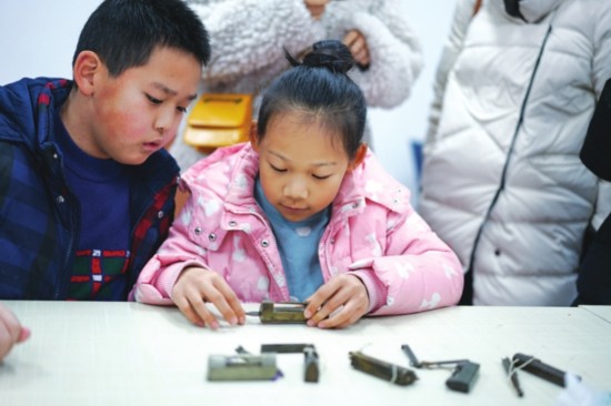 ②孩子们认真研究古锁的秘密。