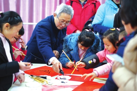 ①孩子们跟着书法爱好者写春联。