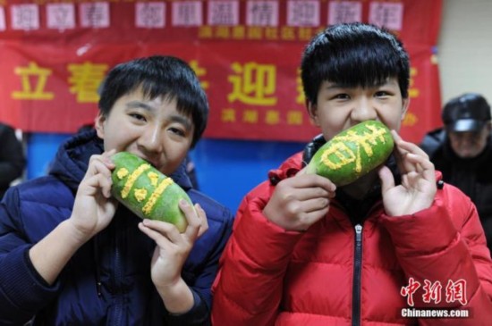 资料图:安徽合肥滨湖惠园社区计生办组织辖区内流动人员家庭和留守儿童一起参加咬春活动。 中新社记者 张娅子 摄