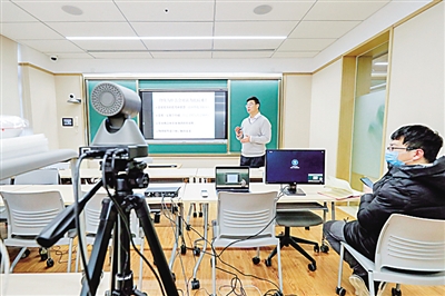 北京大学教师黄建斌(左)正在为大二学生在线远程教授物理化学课程。新华社记者 沈伯韩摄