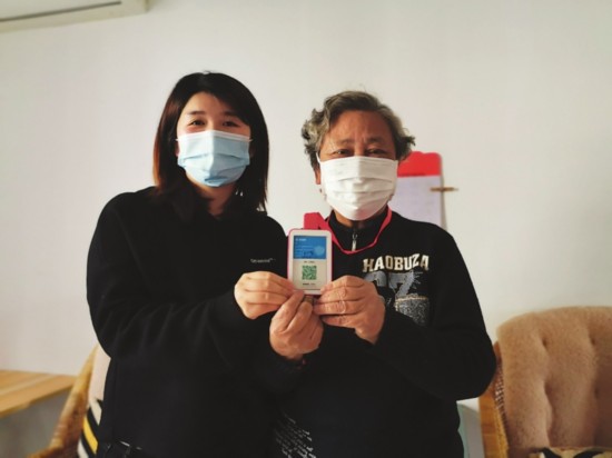 　　社区工作人员上门帮助老人申领苏城码实体卡。　　记者吴丽婷摄