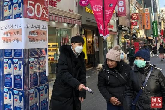 （资料图）2月8日，在首尔明洞地区，销售人员和到访游客大多佩戴口罩。中新社记者 曾鼐 摄