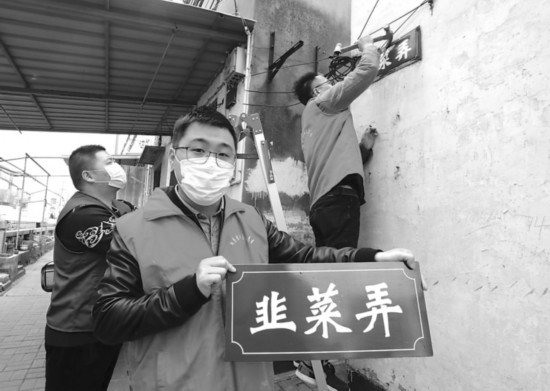 　　志愿者为韭菜弄换上新名牌。记者　杭兴微　摄