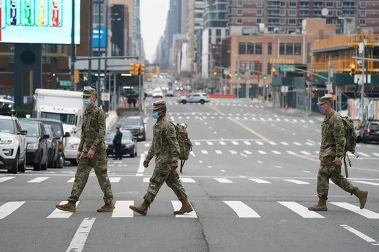 美国国民警卫队成员戴口罩走在街头（法新社）