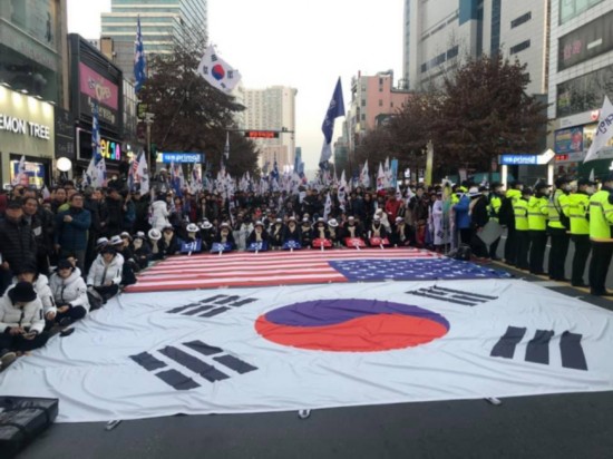 2018年12月,支持者集会声援朴槿惠,星条旗铺一地。(韩国《每日新闻》)