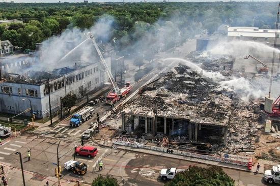 ↑周四,在明尼阿波利斯警察第三分局附近,消防员正与大火搏斗。图据《华尔街日报》