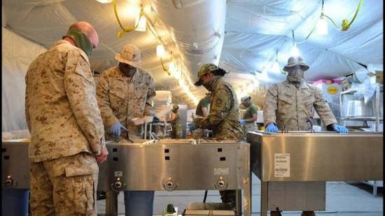  美军士兵在贾贝尔空军基地戴口罩进入食堂就餐